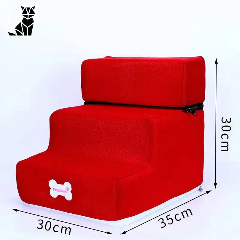 Une chaise rouge avec un bouton blanc, sur laquelle figure l’inscription ’Escalier pour petits chiens avec trois marches’