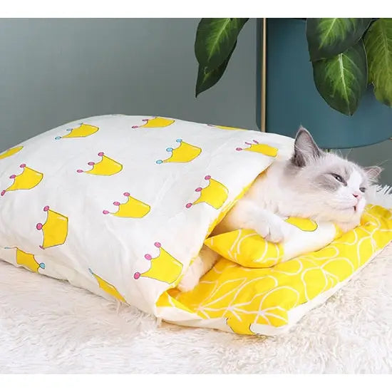 Chat se relaxant sur un lit douillet en coton avec un oreiller jaune et blanc